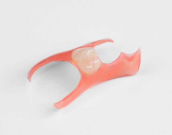 Red dental tool with a white background
