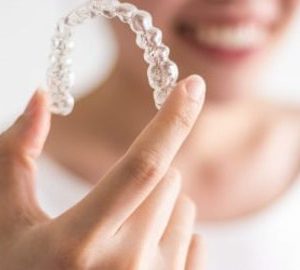 A lady holding clear retainer