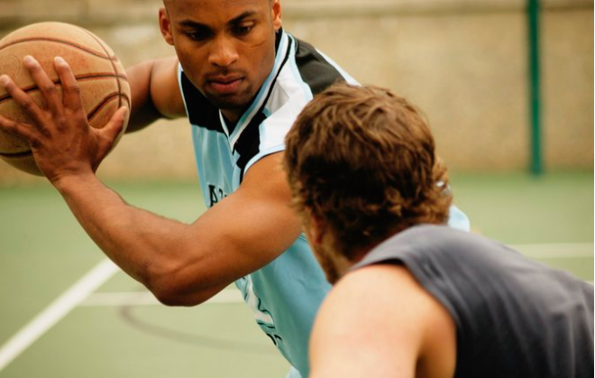 Two men playing basket ball