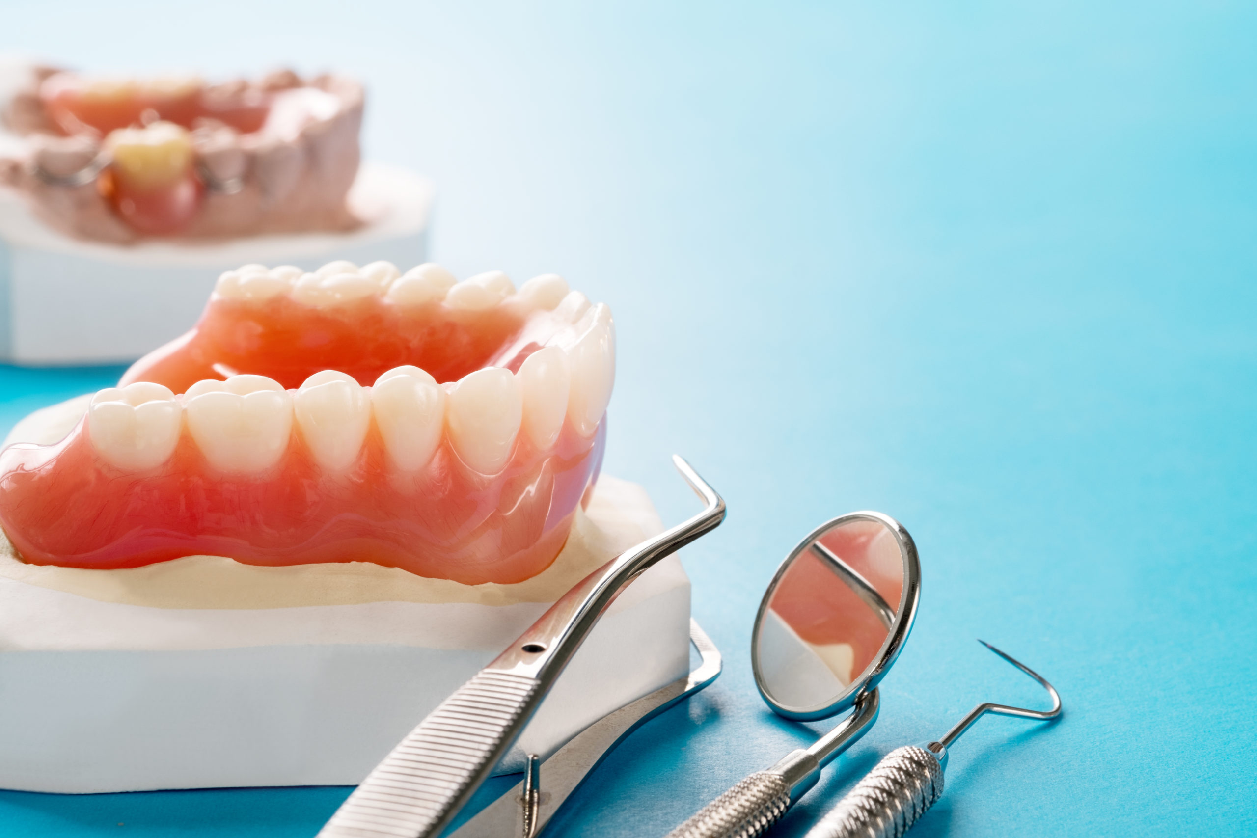 Close up , Complete denture or full denture on blue background.