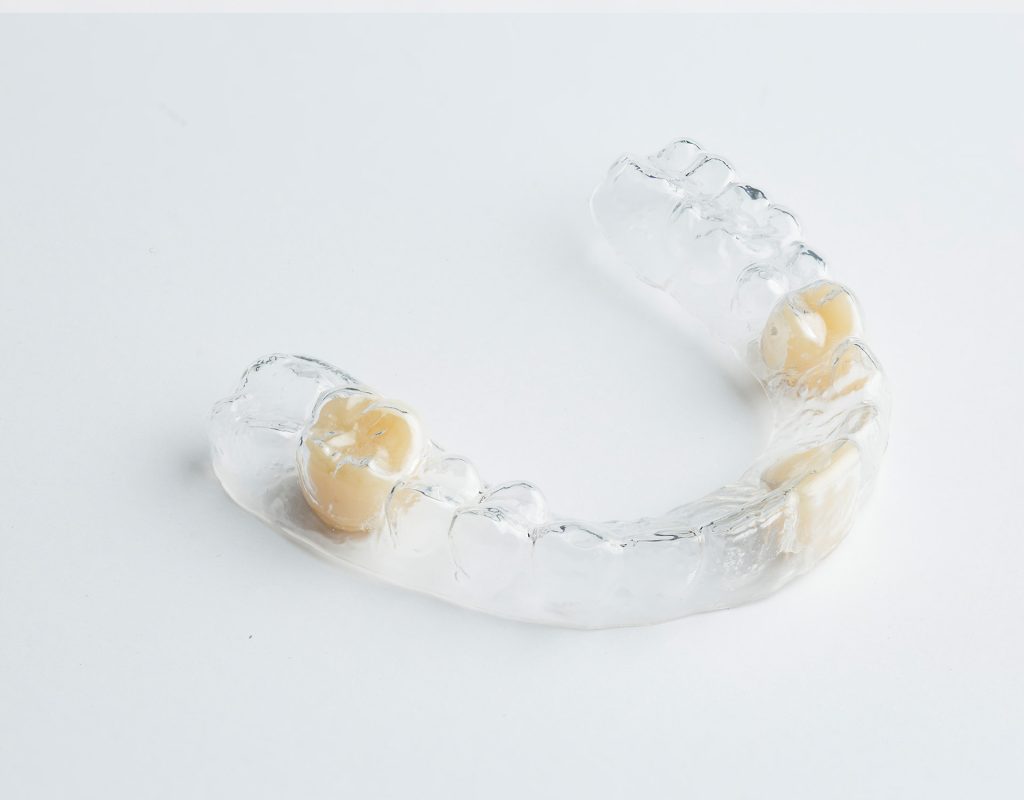 an essix retainer with tooth on a white table