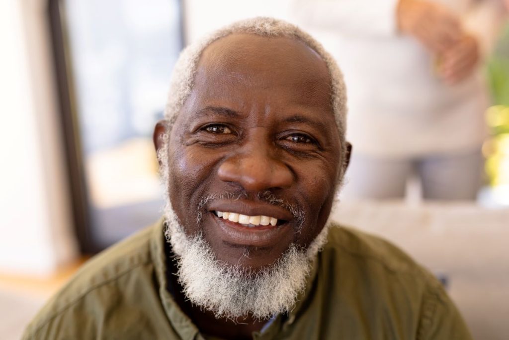 an gray-haired african american man smiling at the camera