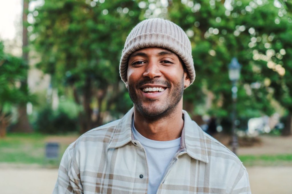 man wearing a beanie smiling at the camera
