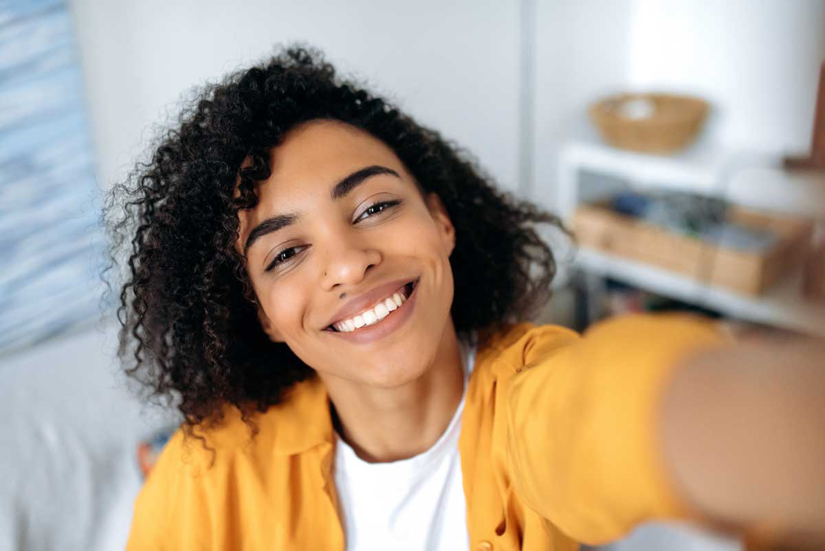 a young woman taking a selfie smiling at the camera after a smile makeover