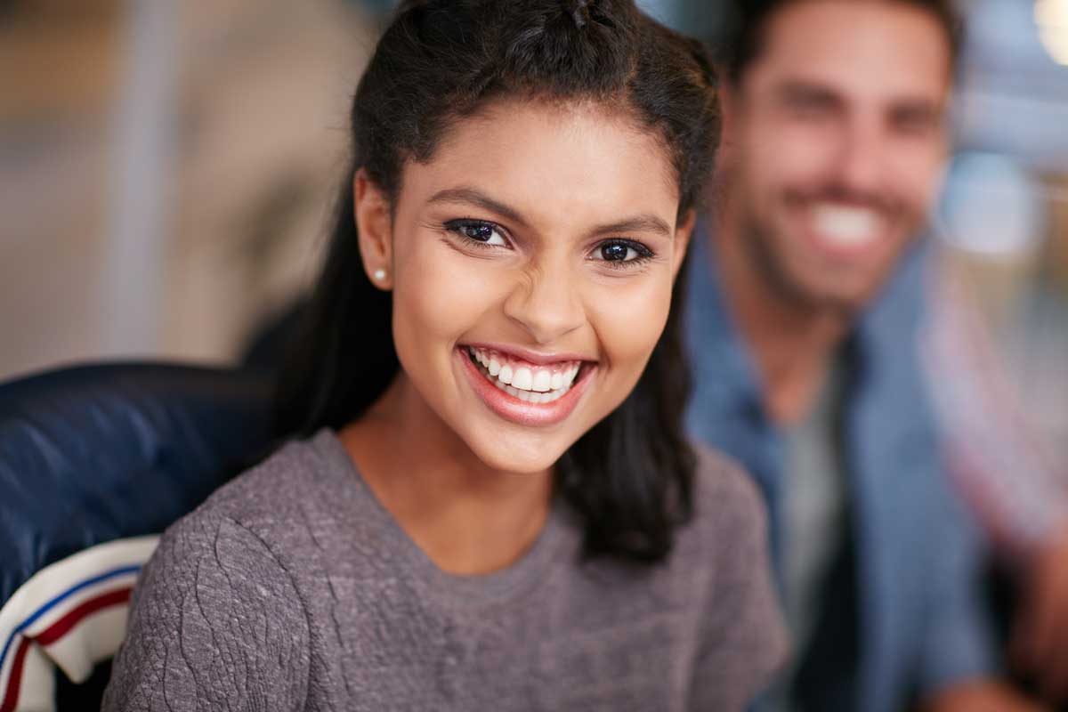 a young woman with straight teeth smiling at the camera