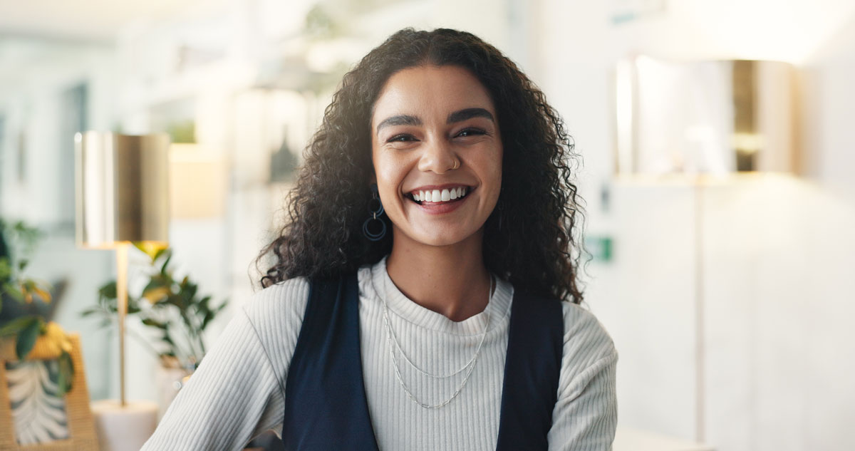 Confident young professional smiling in a modern, well-lit office setting